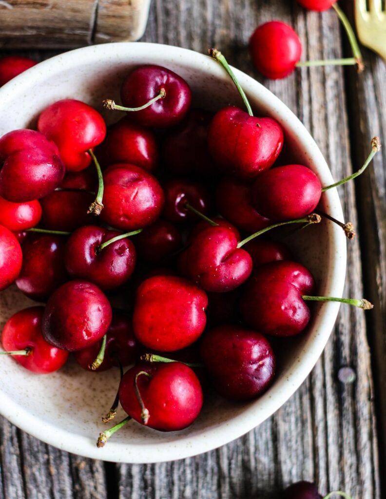 bowl of cherries on a wooden plank