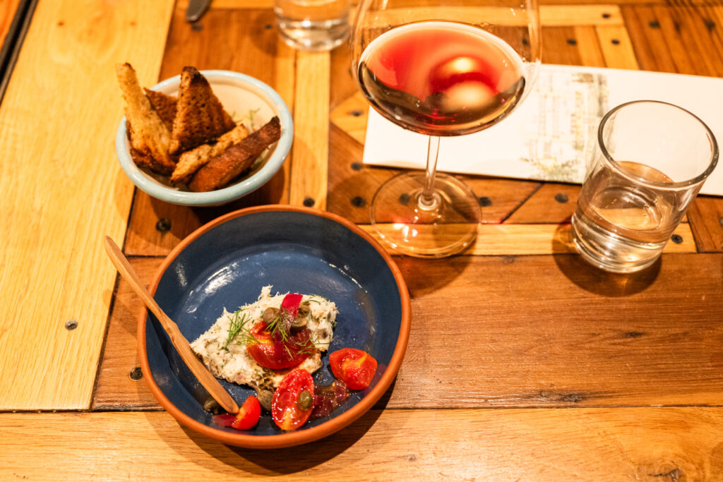 Dish on table with bread and wine glass at Boonville Hotel + Restaurant