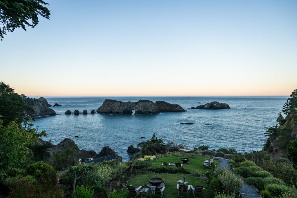 View of ocean with rock formations on a bay at sunset at The Harbor House Inn, Restaurant, & Farm