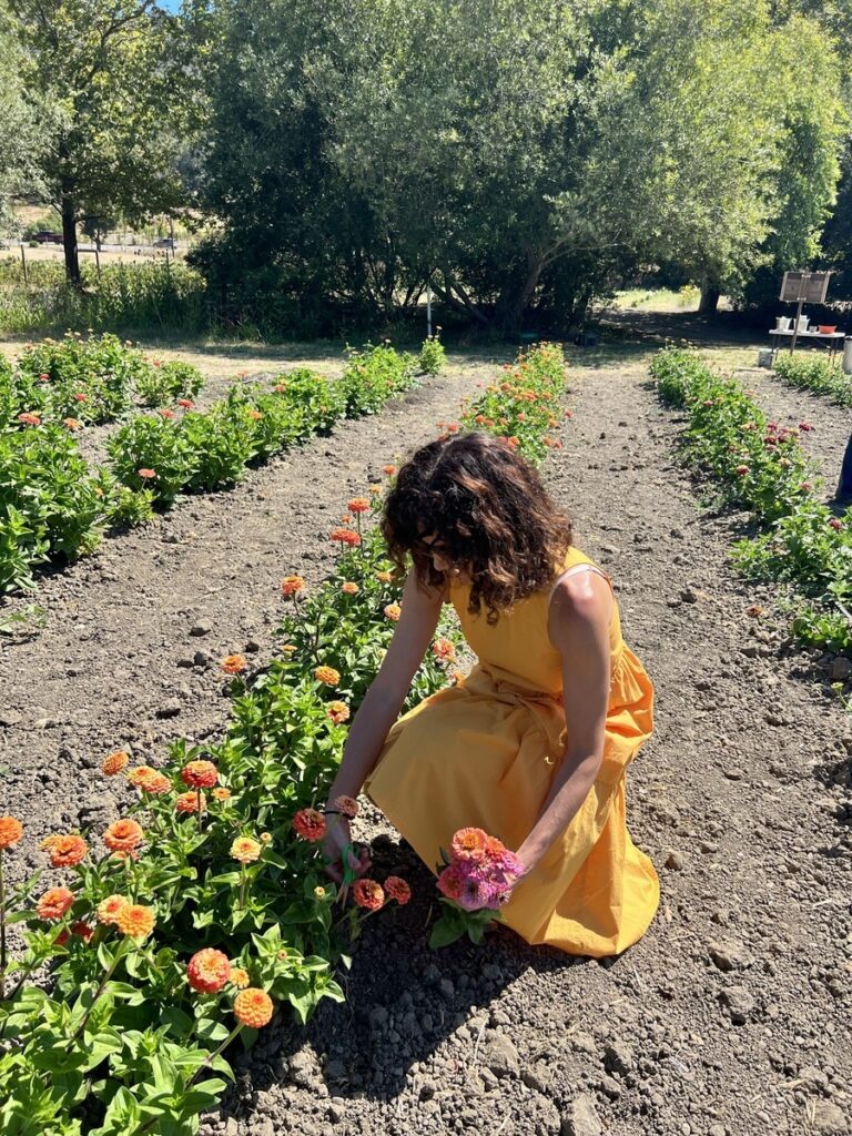 woman in yellow dress picking flowers