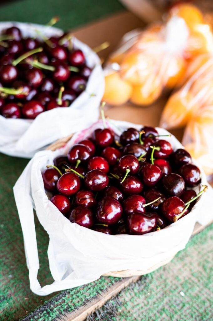 bags of cherries at a farm stand