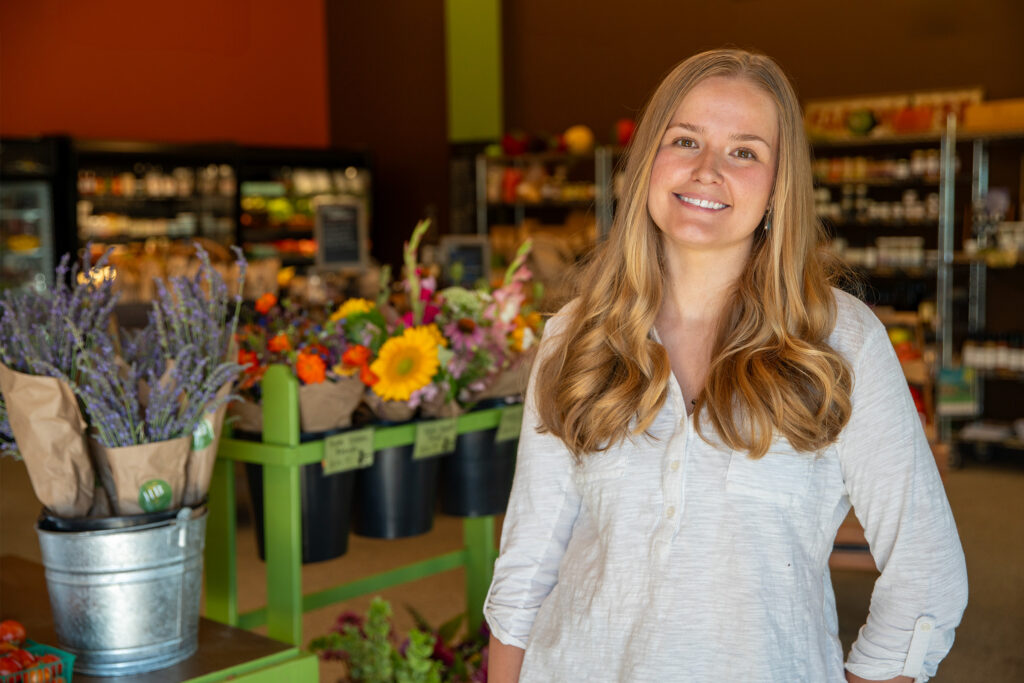 Portrait of woman with flowers and produce behind her