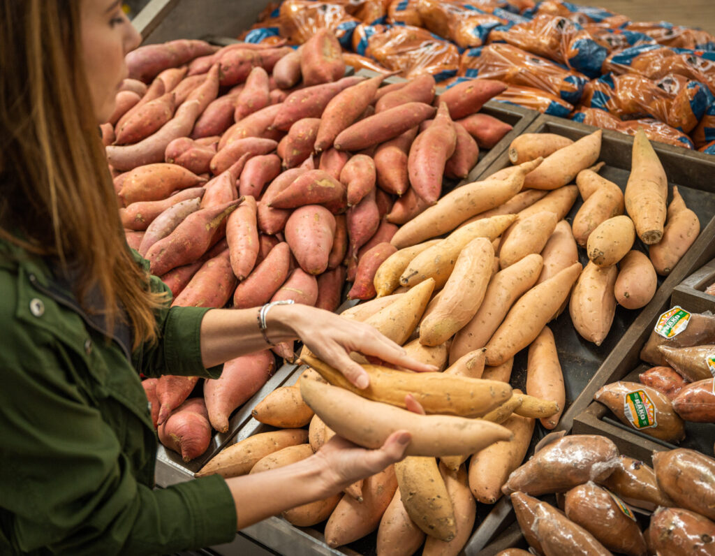 A woman shopping for California Grown sweetpotatoes