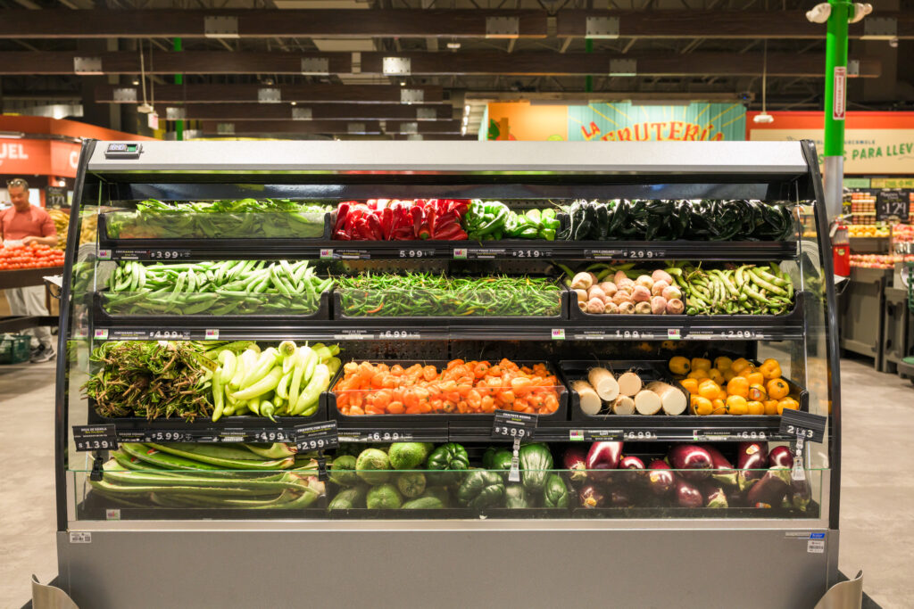 Refrigerated case in a supermarket filled with fresh produce