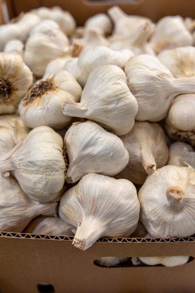 garlic piled in a cardboard box